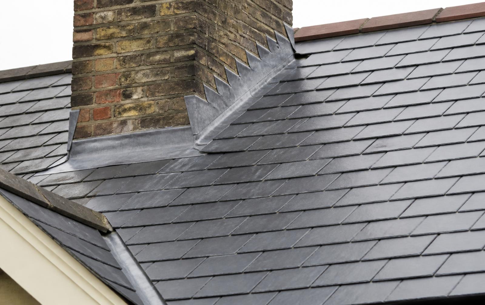 Slate roof with renewed lead flashing around a brick chimney